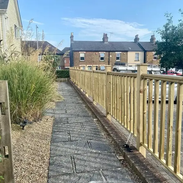 Timber spindle railing running alongside a paved footpath
