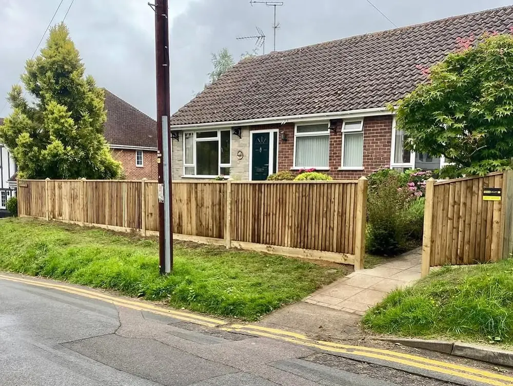 Closeboard boundary fence along a pavement in front of a bungalow