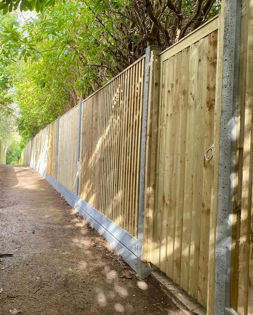 Closeboard fence with concrete gravel boards running beside a footpath