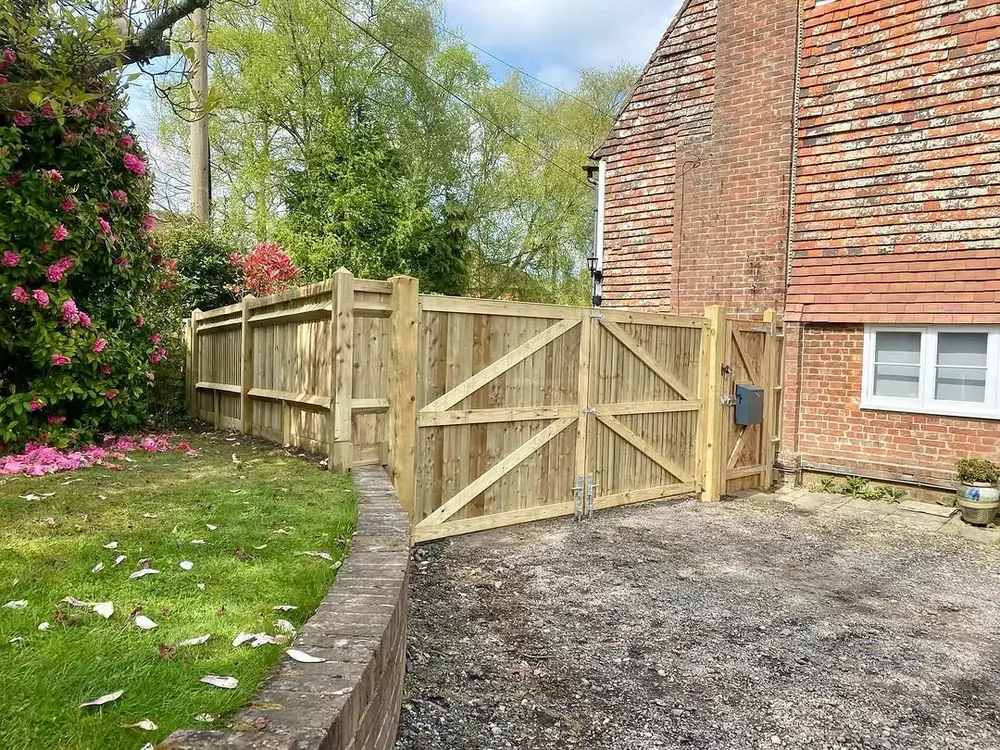 Matching closeboard gates and fencing at the entrance to a tiled cottage