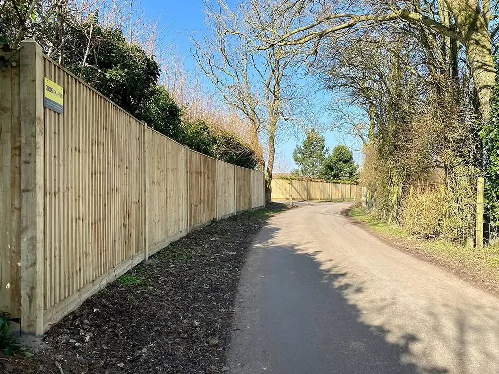 Long closeboard fence following a curving country lane