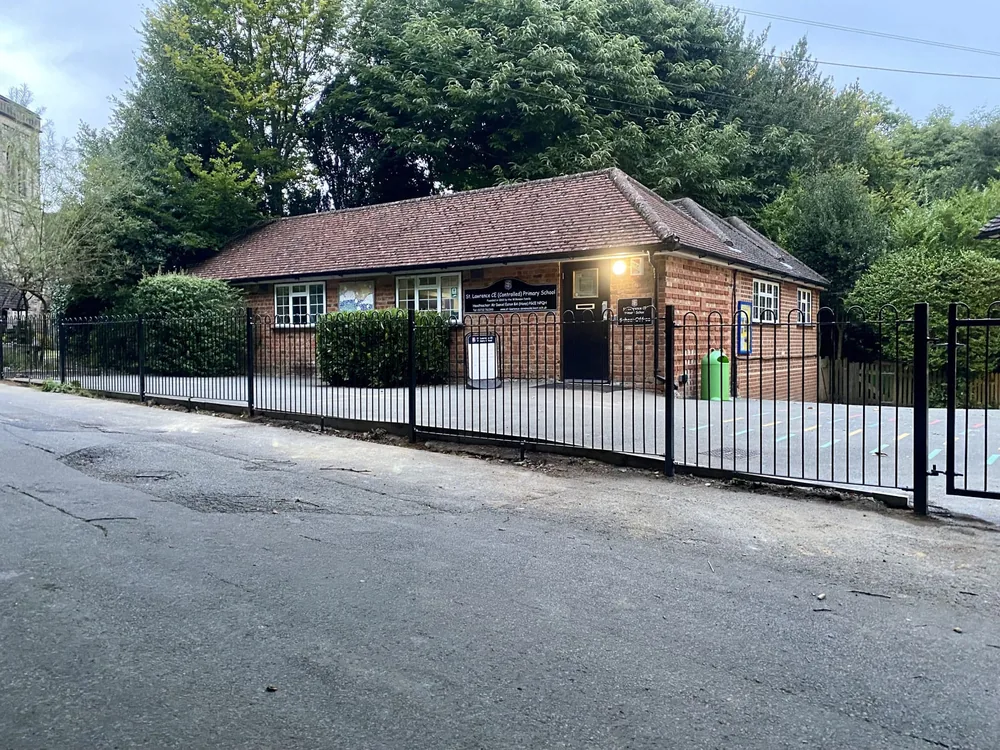 Black bow-top railings along the frontage of St Lawrence CE Primary School