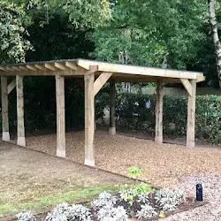 Timber pergola with a gravel walkway running beneath it through a planted garden