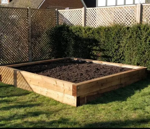 Raised bed built from timber sleepers, filled and ready for planting